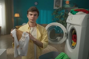 dark-haired man standing next to a washing machine