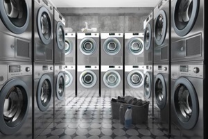 row of washing machines with laundry in a basket