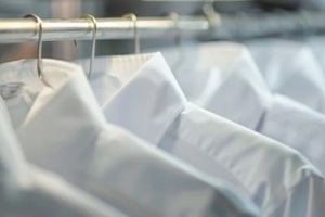 freshly ironed shirts hanging in a row