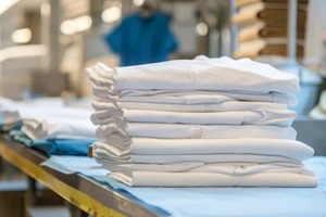 folded sheets, surgical clothes, and iron on white background